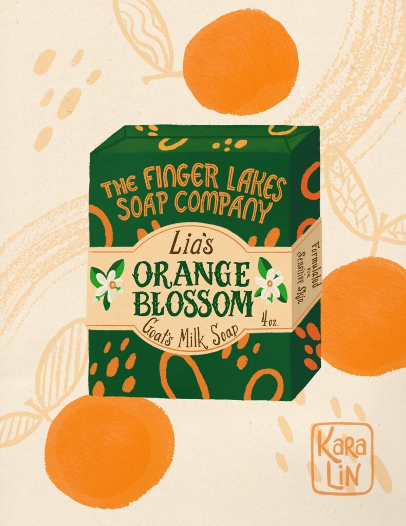 Green and orange packaging for soap. Text reads "Lia's Orange Blossom Goat's Milk Soap".